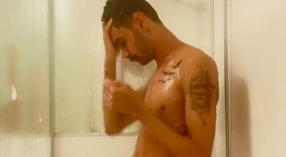 A young, hairy guy with a big dick taking a shower.